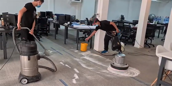 Nhân viên dịch vụ giặt thảm văn phòng đang tiến hành giặt thảm cho khách hàng
